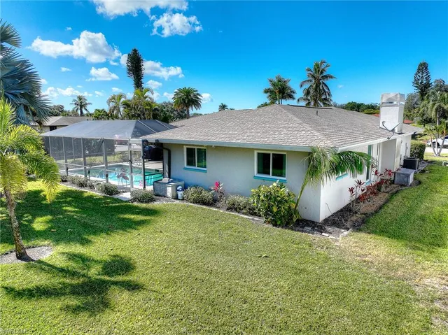 a view of a house with a yard and potted plants