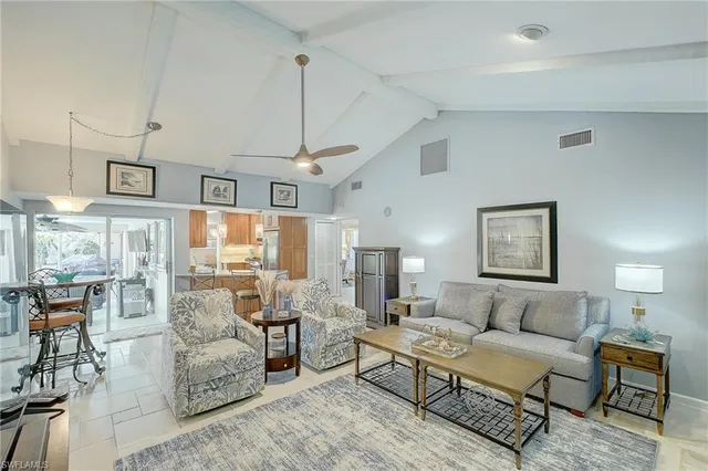 a living room with furniture kitchen view and a large window