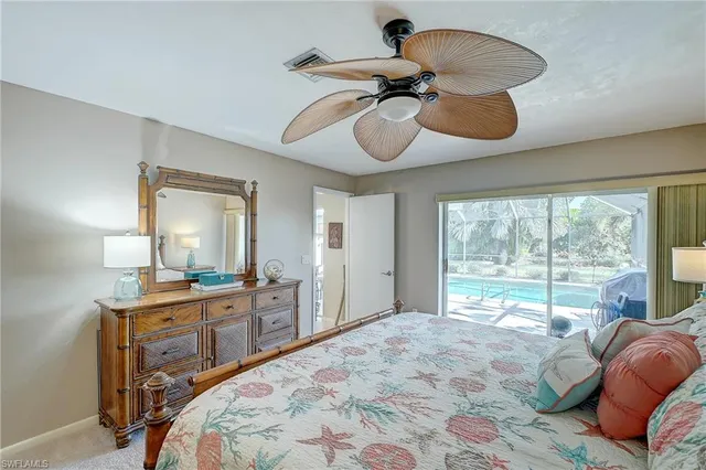 a bedroom with a bed and a large mirror on the dresser