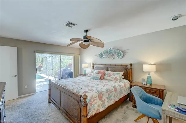 a bedroom with a large bed a chandelier and a window