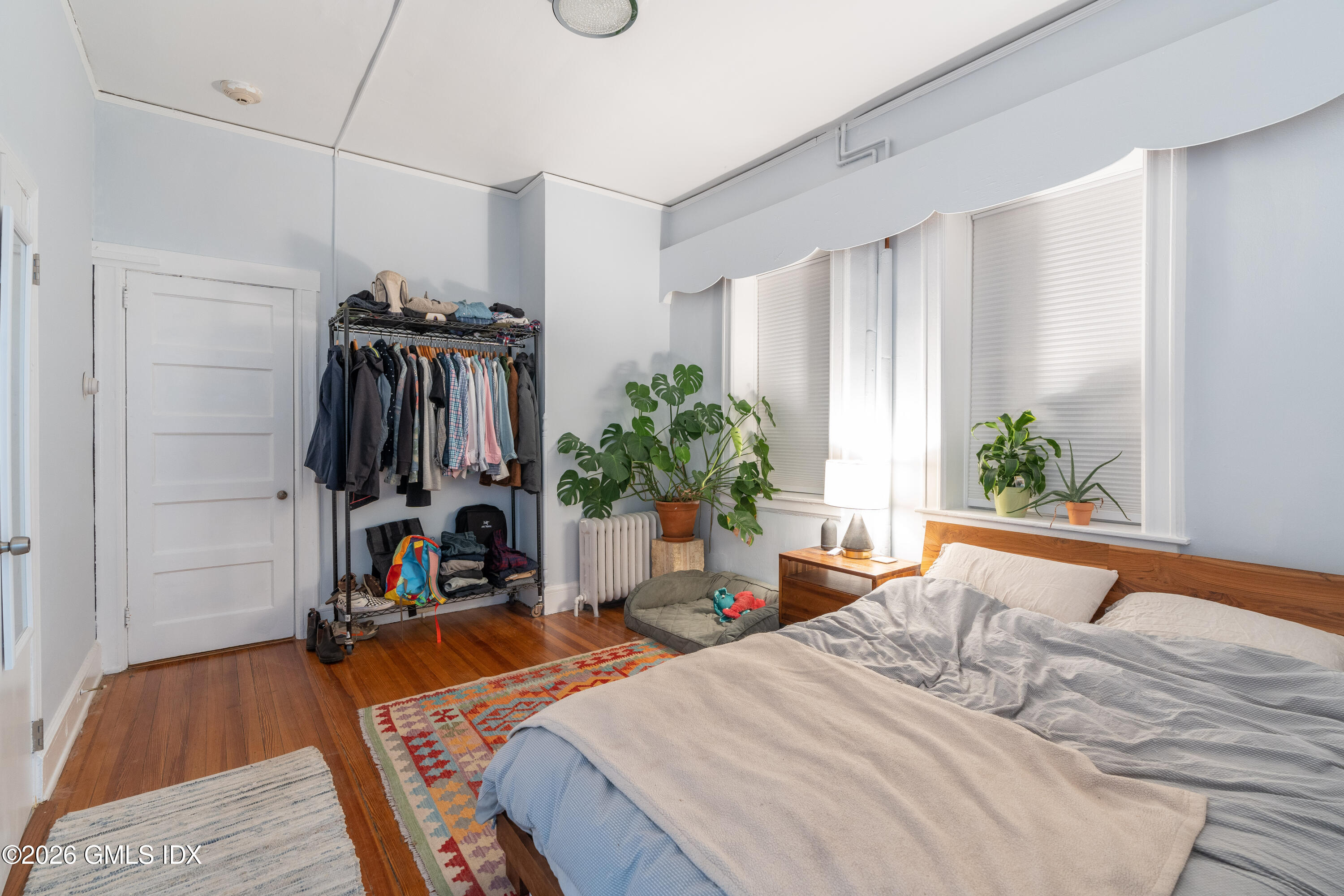 140 Hamilton Avenue, Unit 1 Greenwich, CT 06830 - Photo 3 of 7 a bedroom with a bed a potted plant and a window