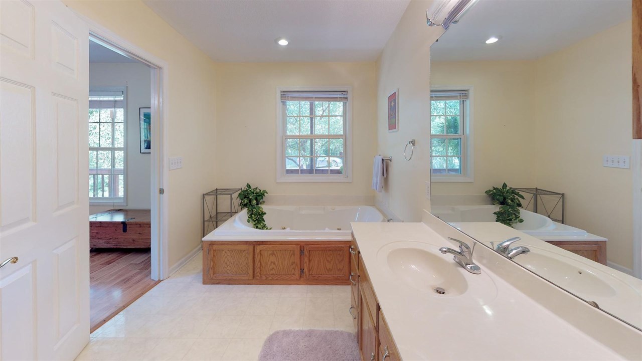 2286 Old Federal Road Ocoee, TN 37361 - Photo 19 of 56 a en suite bathroom with a double vanity sink a mirror and a bathtub