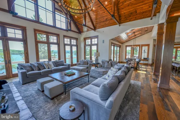 a kitchen with stainless steel appliances granite countertop a stove a refrigerator a dining table and chairs with wooden floor