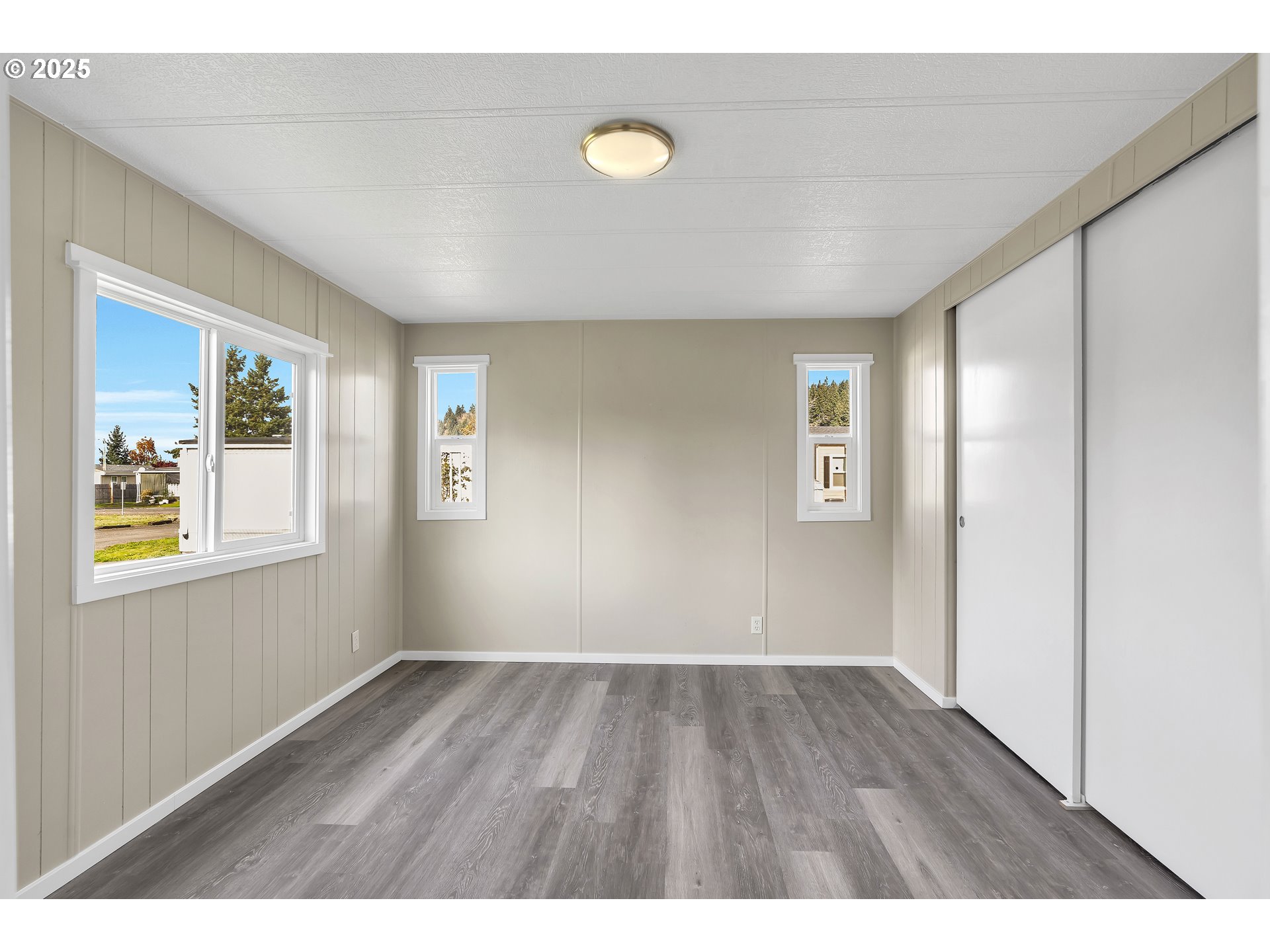 10701 Southeast Highway 212, Unit J3 Clackamas, OR 97015 - Photo 13 of 42 a view of an empty room with wooden floor and window
