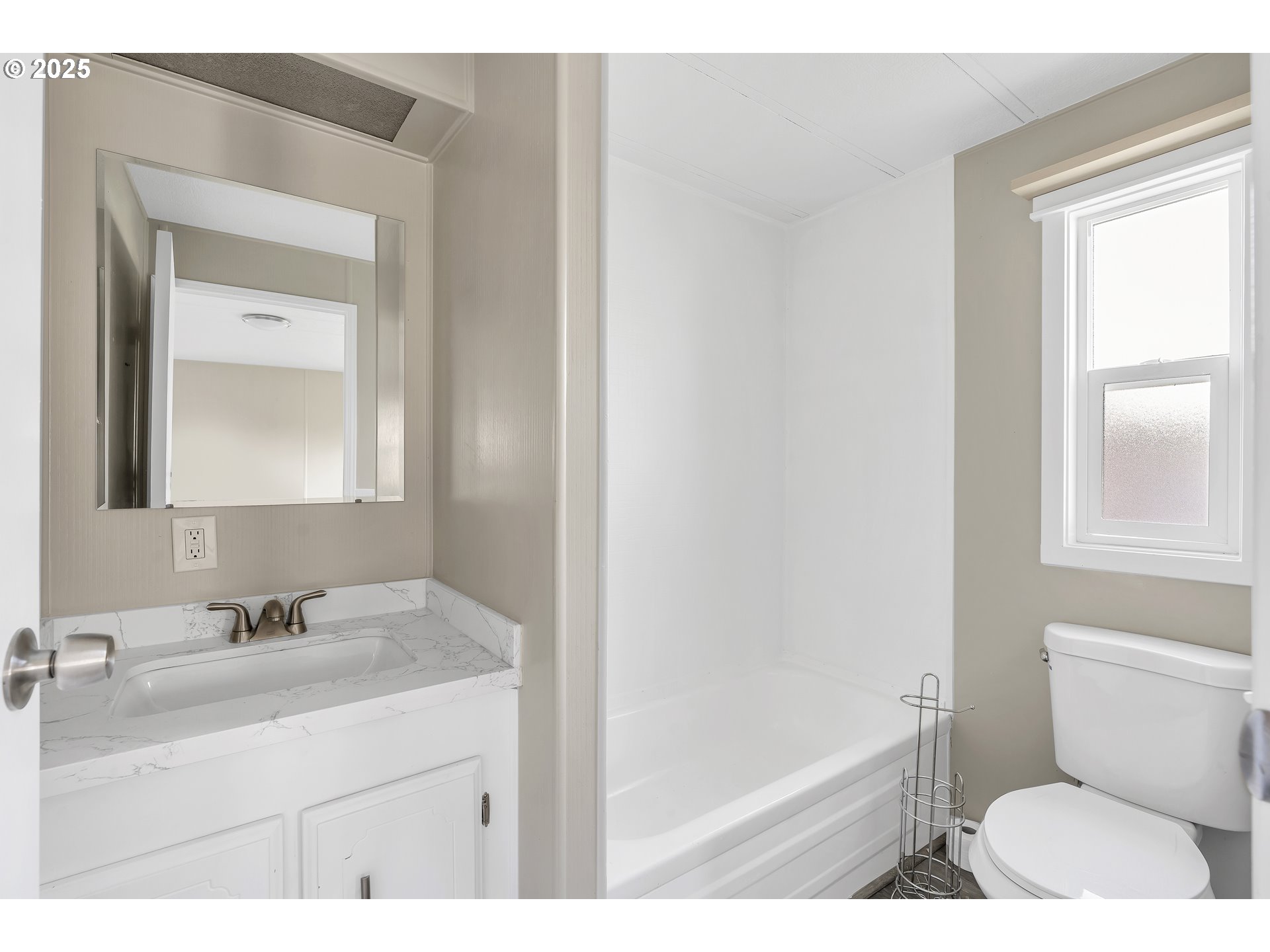 10701 Southeast Highway 212, Unit J3 Clackamas, OR 97015 - Photo 15 of 42 a bathroom with a sink a toilet a mirror and vanity