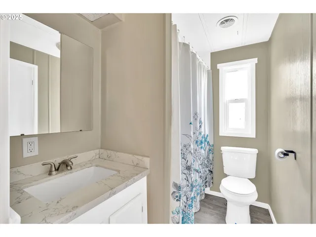 a bathroom with a granite countertop sink toilet and shower