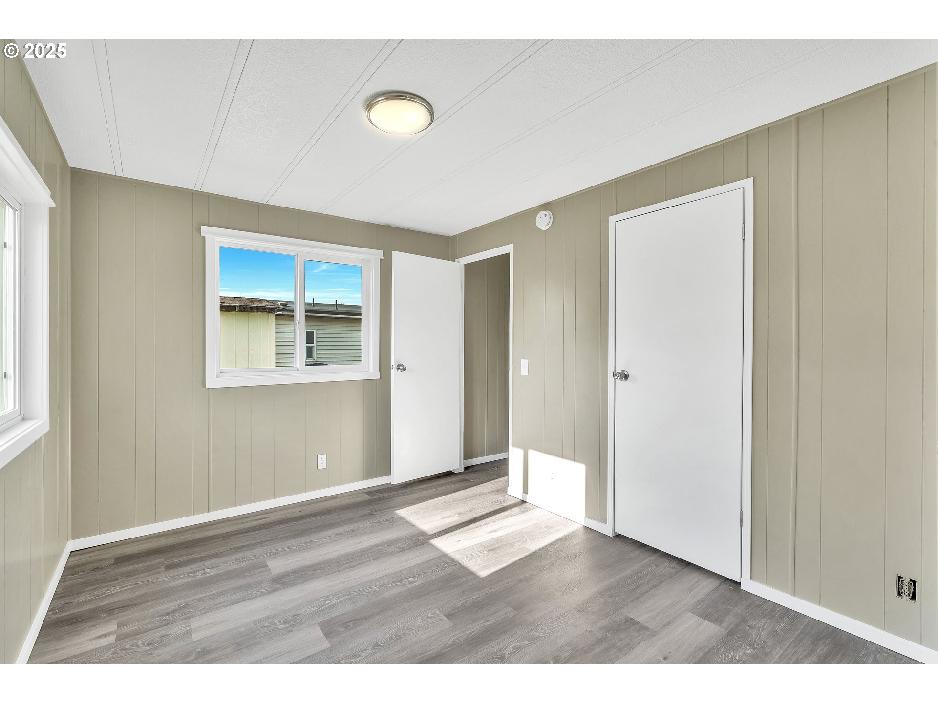 10701 Southeast Highway 212, Unit J3 Clackamas, OR 97015 - Photo 22 of 42 a view of an empty room with wooden floor and a window