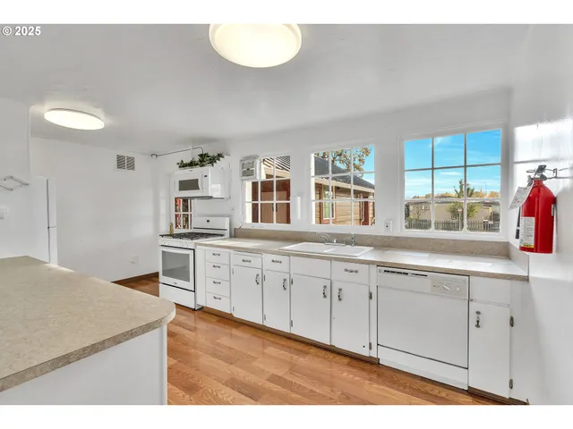 a kitchen with granite countertop a stove a sink and a wooden cabinets