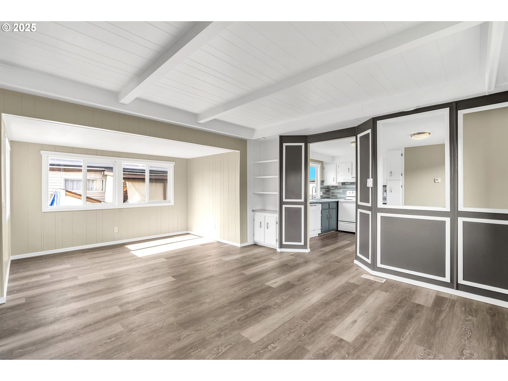 10701 Southeast Highway 212, Unit J3 Clackamas, OR 97015 - Photo 5 of 42 a view of an empty room with window and wooden floor