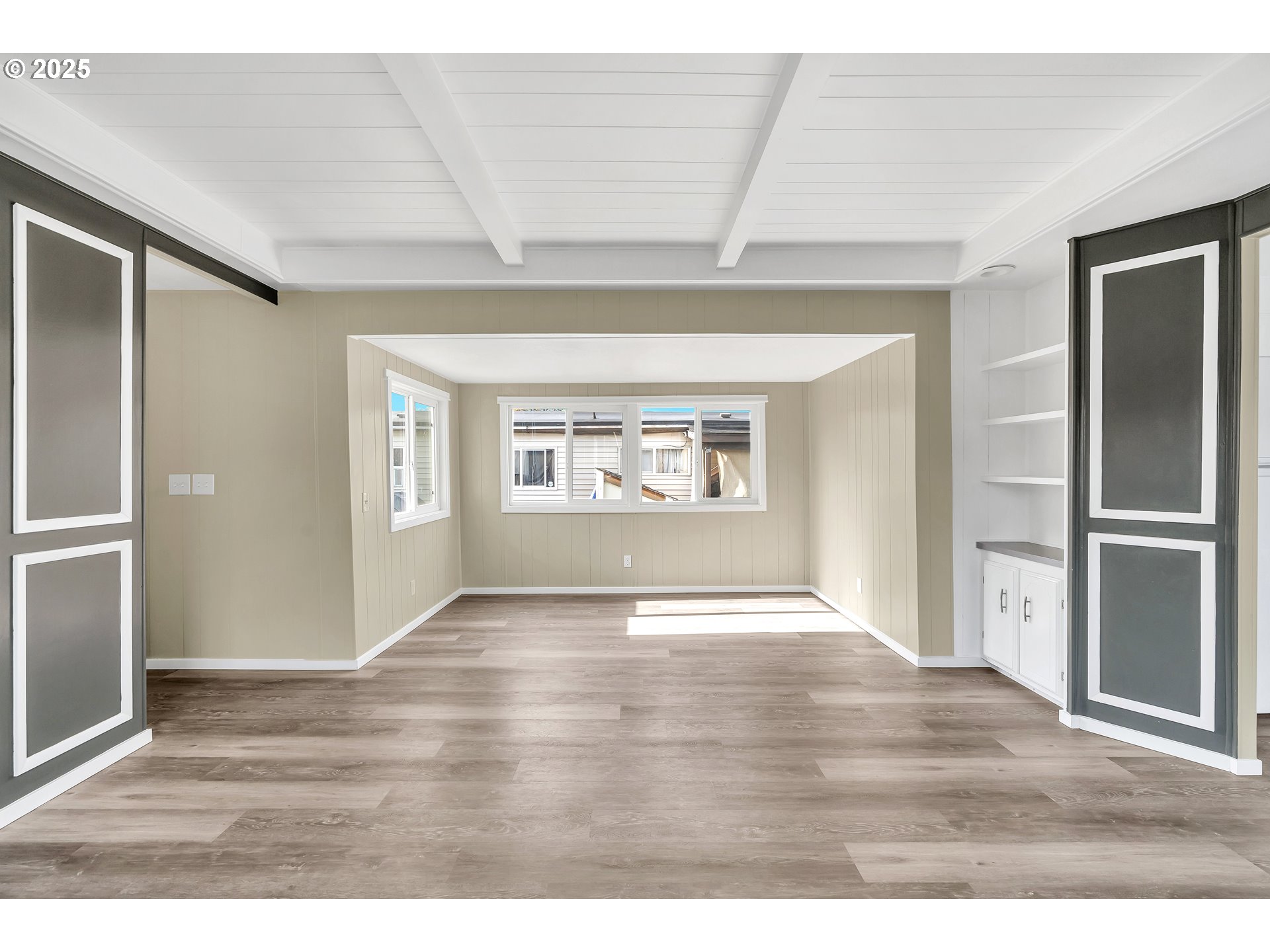 10701 Southeast Highway 212, Unit J3 Clackamas, OR 97015 - Photo 6 of 42 an empty room with wooden floor kitchen view and windows