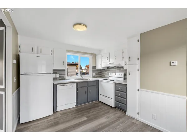 a kitchen with white cabinets and white appliances
