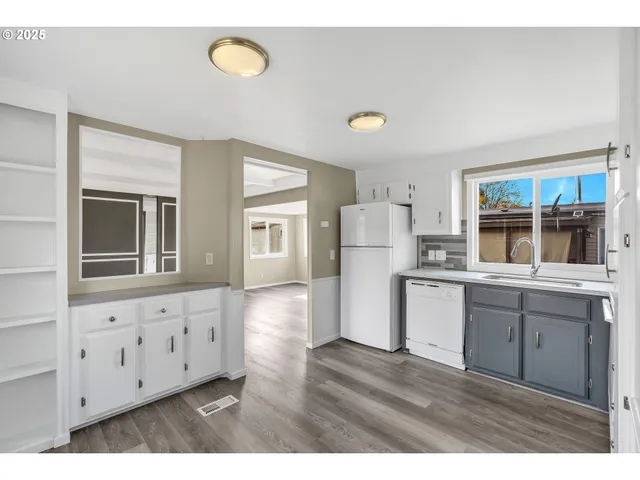 a kitchen with cabinets and wooden floor