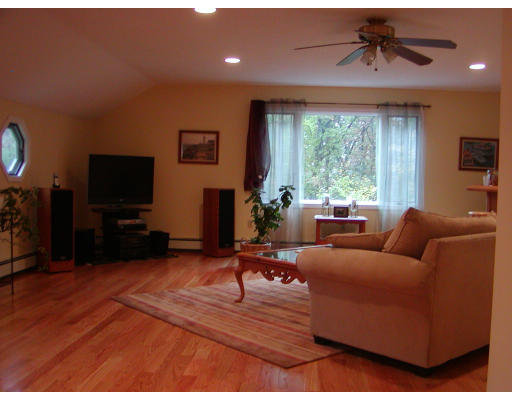 11 Quail Run Road Bellingham, MA 02019 - Photo 8 of 22 a living room with furniture a large window and a flat screen tv