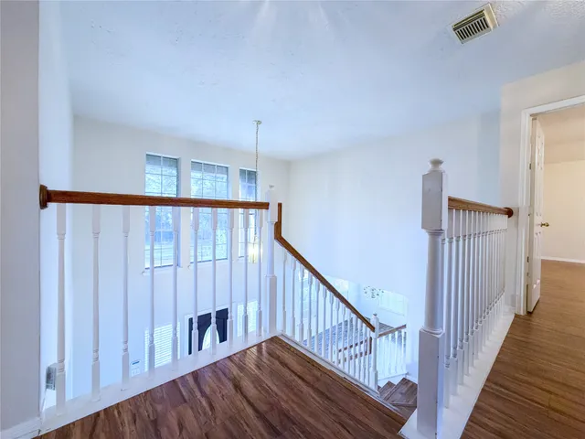 a view of staircase with railing and white walls