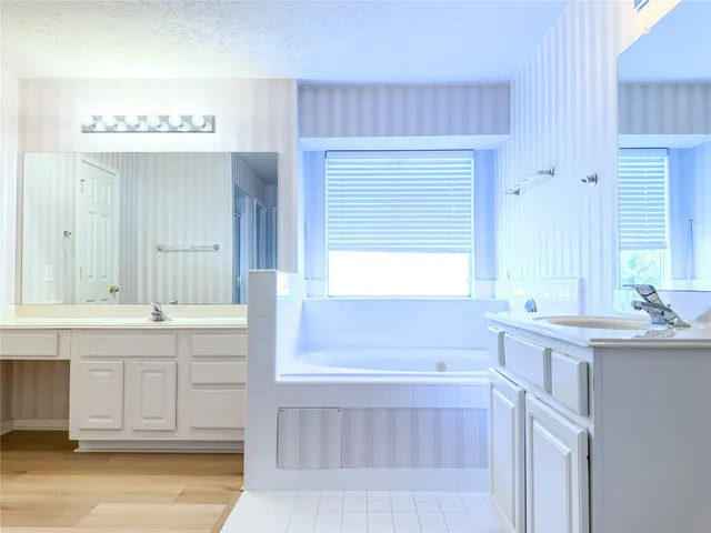 a bathroom with a tub sink and mirror