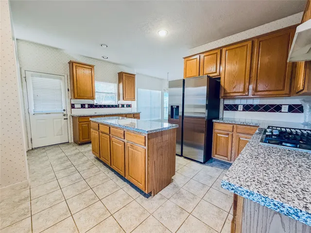 a kitchen with stainless steel appliances granite countertop a stove a sink and a microwave