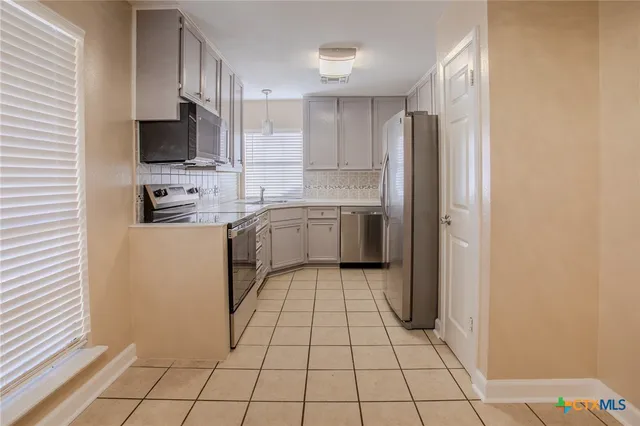 a kitchen with stainless steel appliances a refrigerator sink and microwave