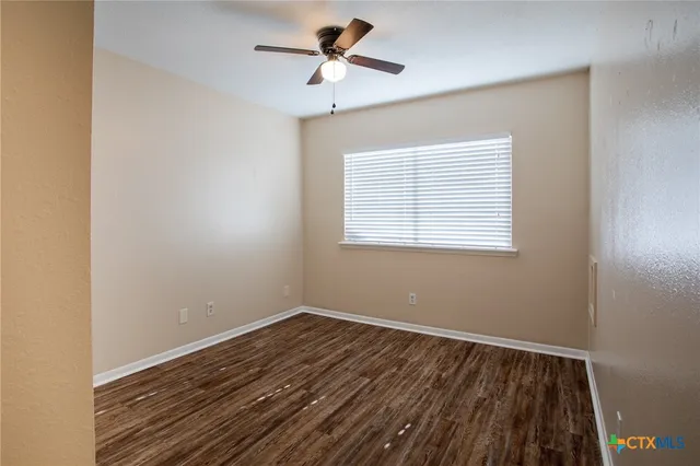 a view of room with window ceiling fan and hardwood floor
