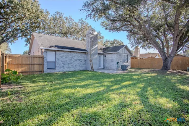 a view of a house with a big yard and large tree