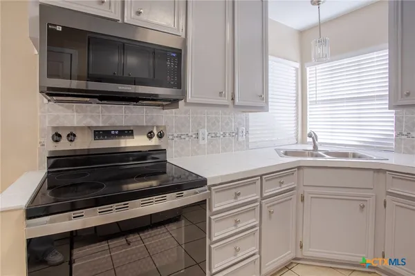 a kitchen with cabinets appliances and a sink