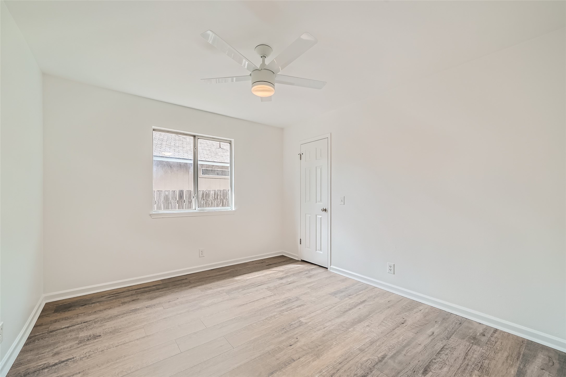 905 Jasmine Trail Georgetown, TX 78626 - Photo 21 of 31 an empty room with wooden floor fan and windows