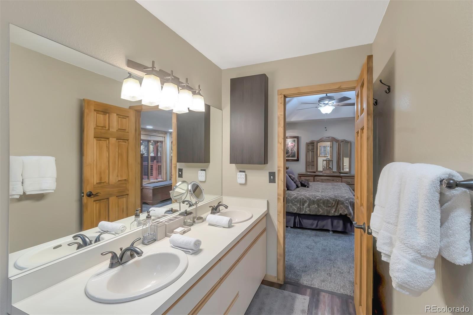 195 Bulldogger Road Bailey, CO 80421 - Photo 15 of 38 a en suite bathroom with double vanity sinks and a mirror