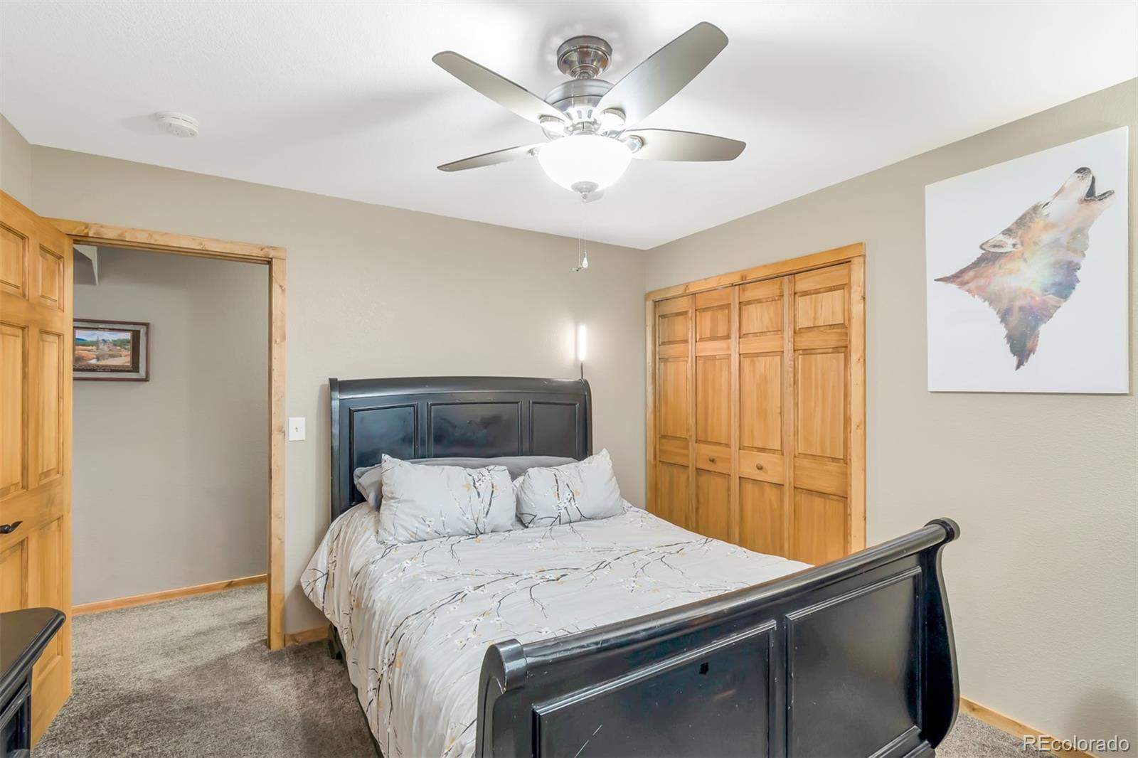 195 Bulldogger Road Bailey, CO 80421 - Photo 20 of 38 a bedroom with a bed and a chandelier