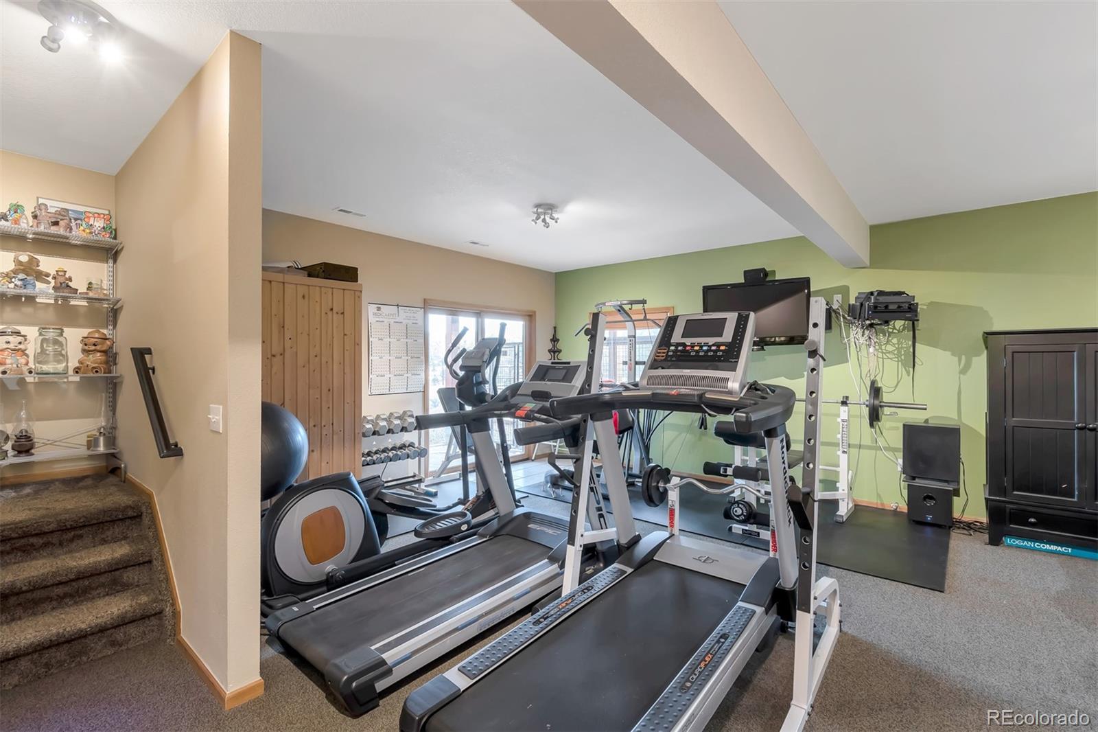 195 Bulldogger Road Bailey, CO 80421 - Photo 22 of 38 a room with gym equipment and a flat screen tv