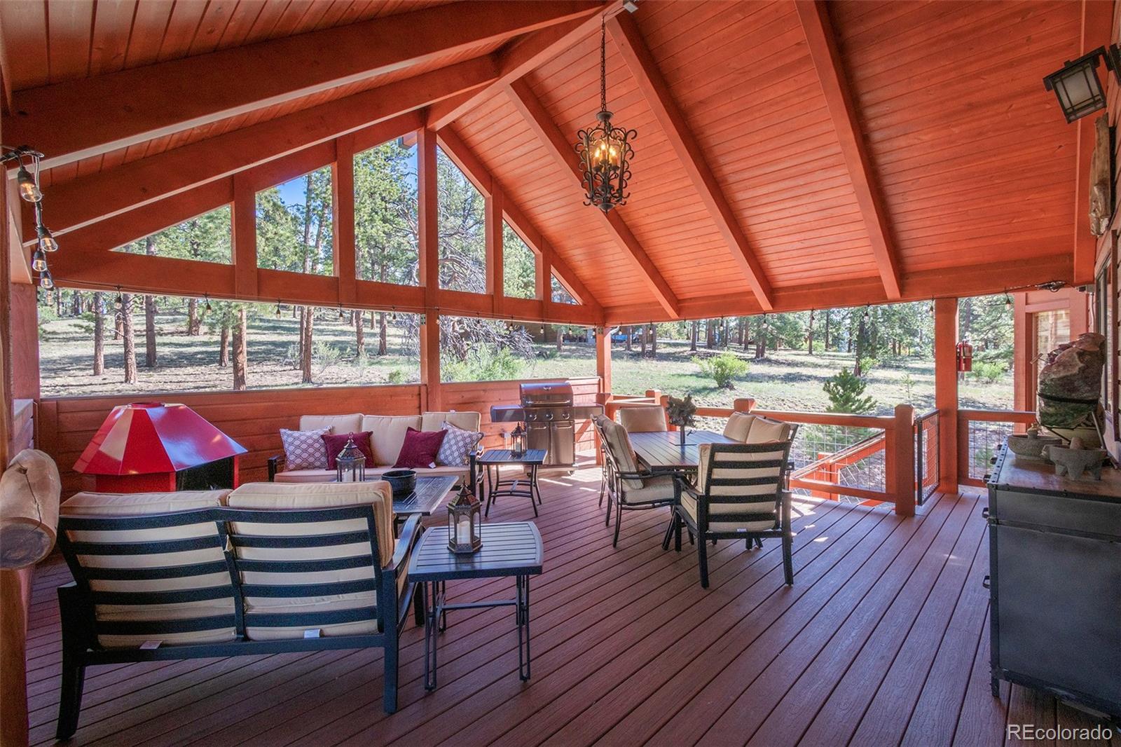 195 Bulldogger Road Bailey, CO 80421 - Photo 8 of 38 a view of a patio with table and chairs and wooden floor