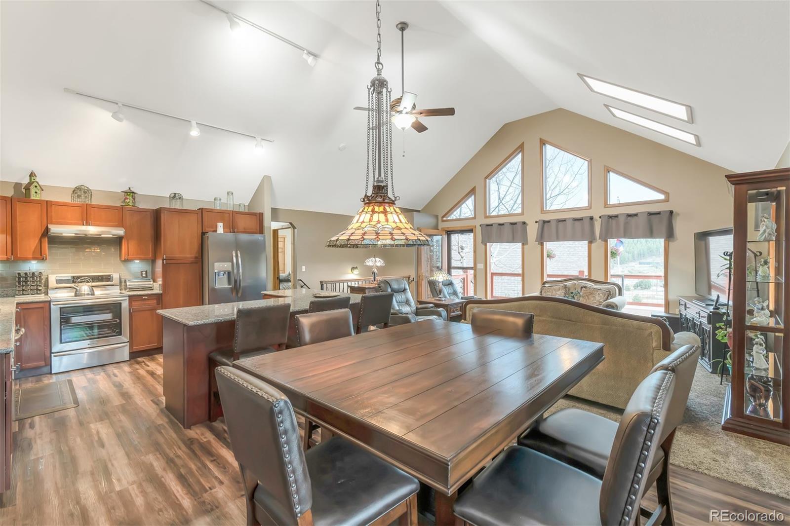 195 Bulldogger Road Bailey, CO 80421 - Photo 10 of 38 a dining room with wooden floor a chandelier a wooden table and chairs