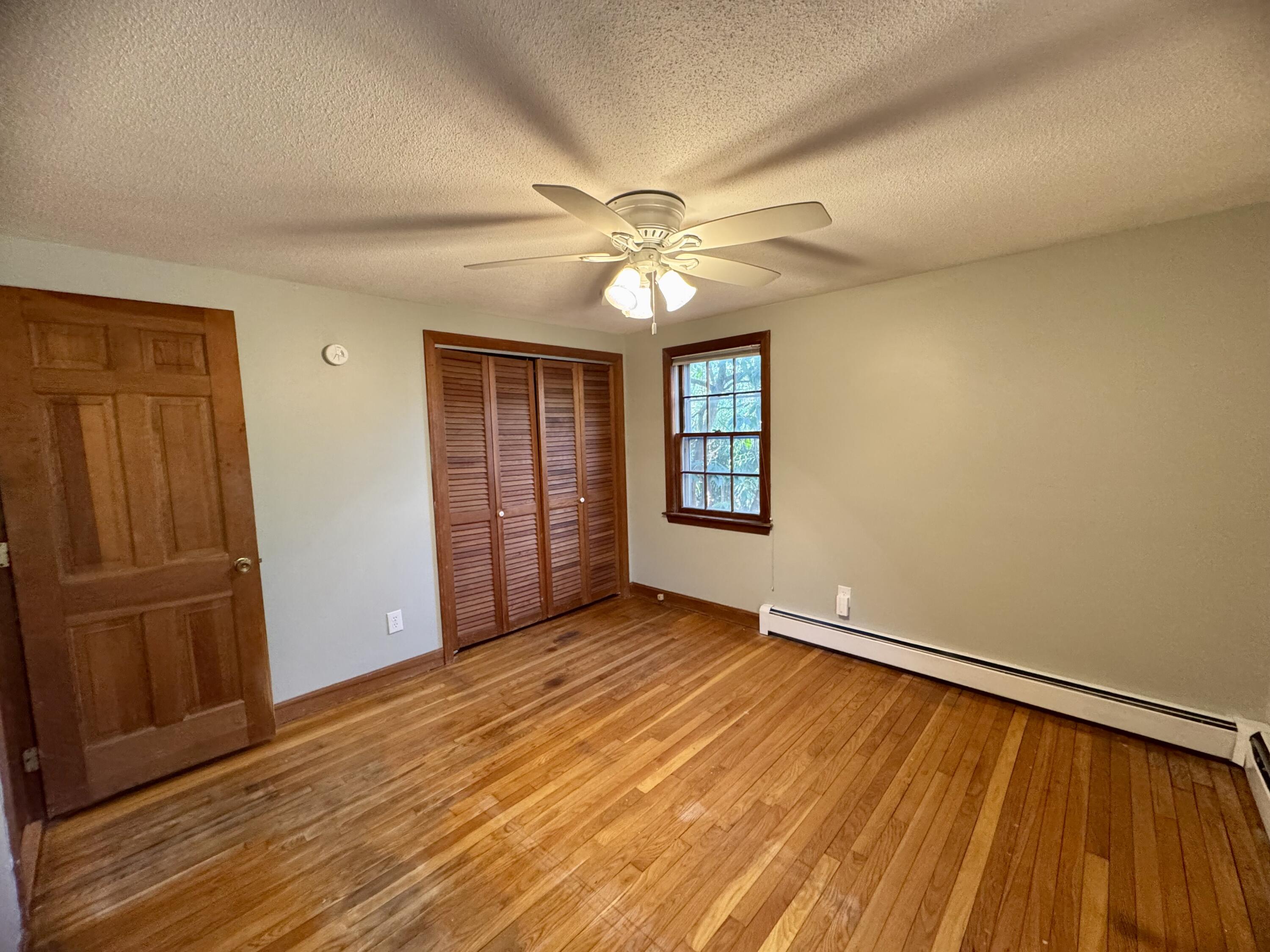 198 Great Marsh Road Centerville, MA 02632 - Photo 15 of 19 an empty room with wooden floor closet and windows