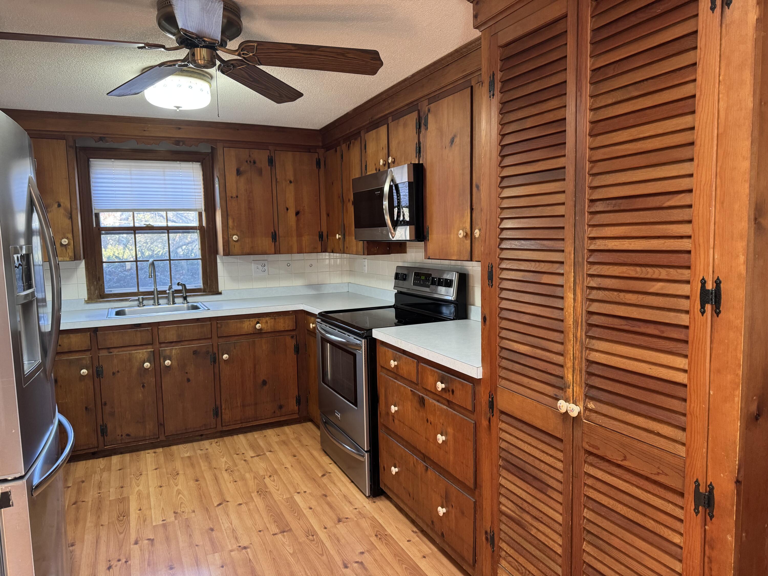 198 Great Marsh Road Centerville, MA 02632 - Photo 5 of 19 a kitchen with stainless steel appliances kitchen island granite countertop wooden cabinets a sink a stove and a window