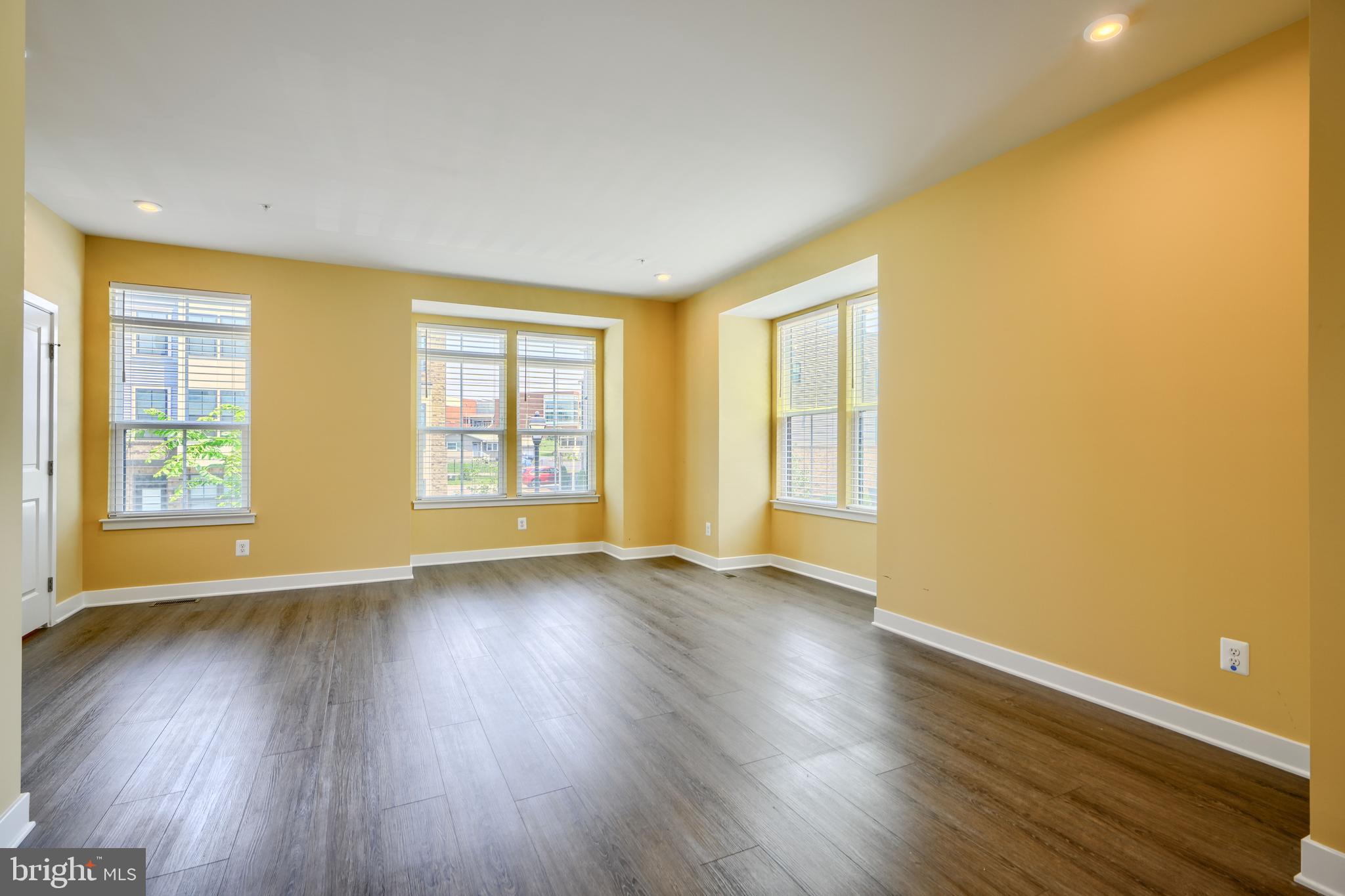 7113 Foundry Mews Baltimore, MD 21222 - Photo 6 of 29 a view of an empty room with wooden floor and a window