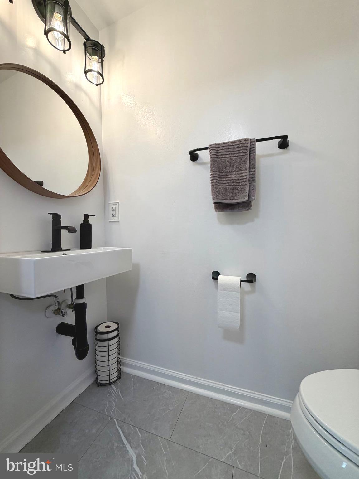 7108 Wheeling Way Gainesville, VA 20155 - Photo 5 of 45 a bathroom with a sink a toilet and a mirror