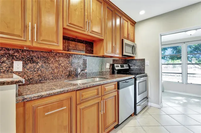 a kitchen with stainless steel appliances granite countertop a sink and cabinets