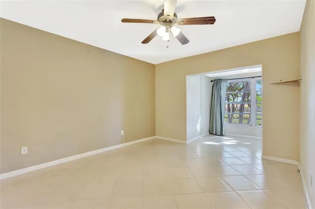 a view of an empty room with chandelier fan