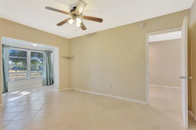 a view of a livingroom with a chandelier fan and windows