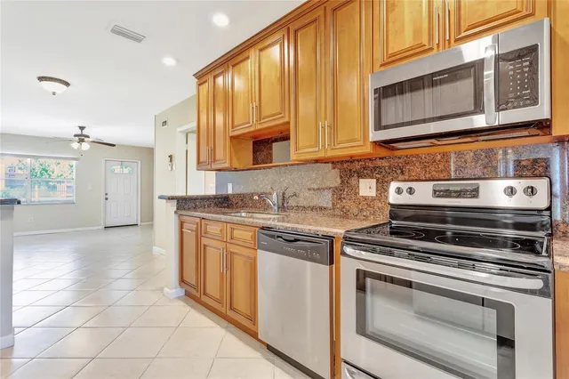 a kitchen with stainless steel appliances granite countertop a stove and a microwave