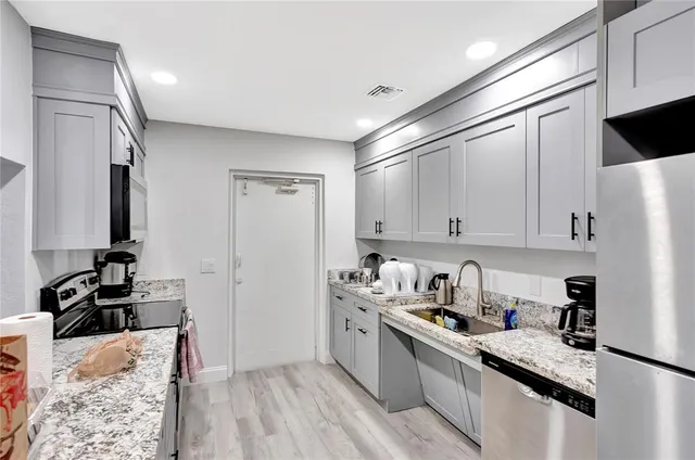 a kitchen with stainless steel appliances granite countertop a sink stove and refrigerator