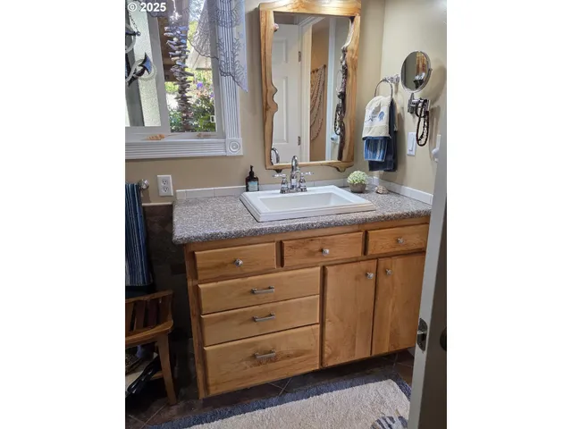 a bathroom with a granite countertop sink and a mirror