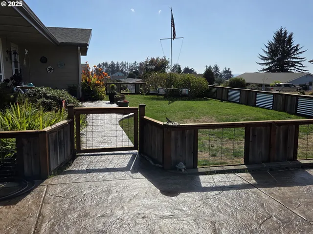 a view of a patio with table and chairs a barbeque with wooden fence