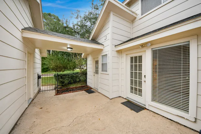 a view of backyard with large window and wooden fence