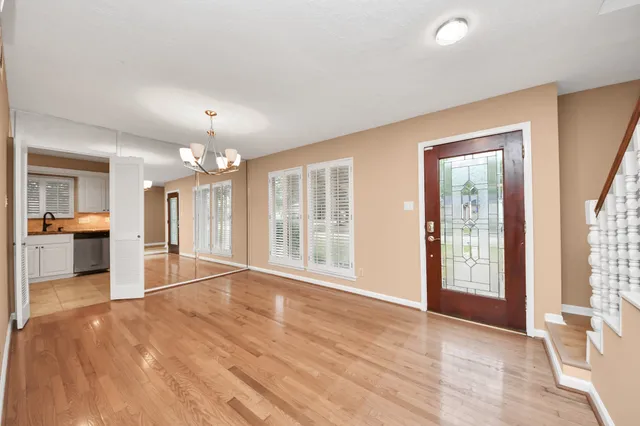 a view of an empty room with kitchen and a window