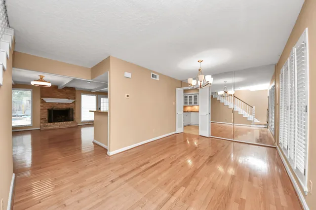 a view of a livingroom with wooden floor a ceiling fan and window