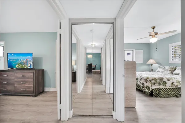 a view of a bedroom with bed and mirror