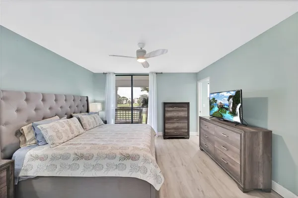 a spacious bedroom with a bed and a flat screen television