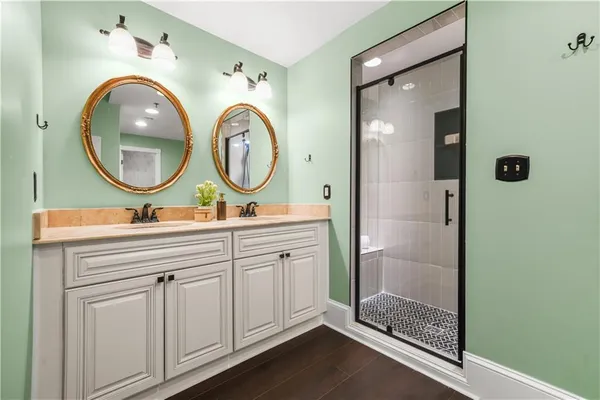 a bathroom with a double vanity sink mirror and shower
