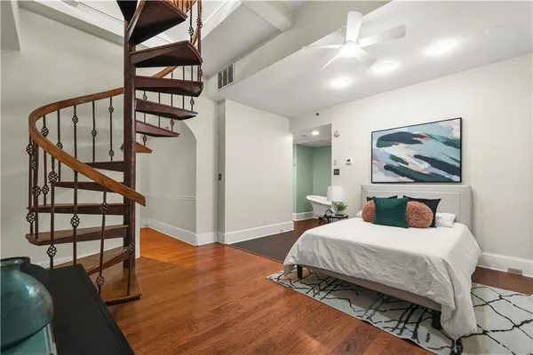 a bedroom with a bed a mirror and paintings on the wall