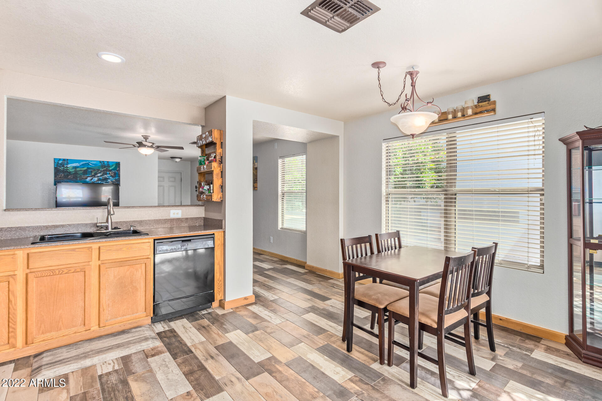 3466 South Chaparral Road Apache Junction, AZ 85119 - Photo 8 of 29 a kitchen with granite countertop dining table chairs cabinets and stainless steel appliances