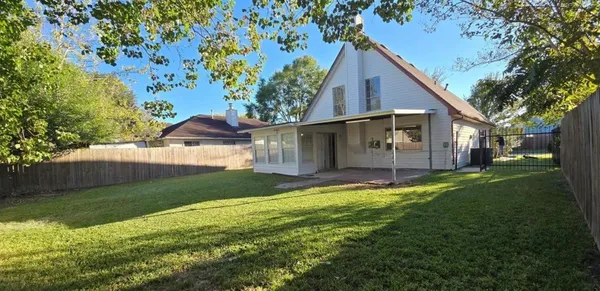 a view of a house with a big yard plants and large tree
